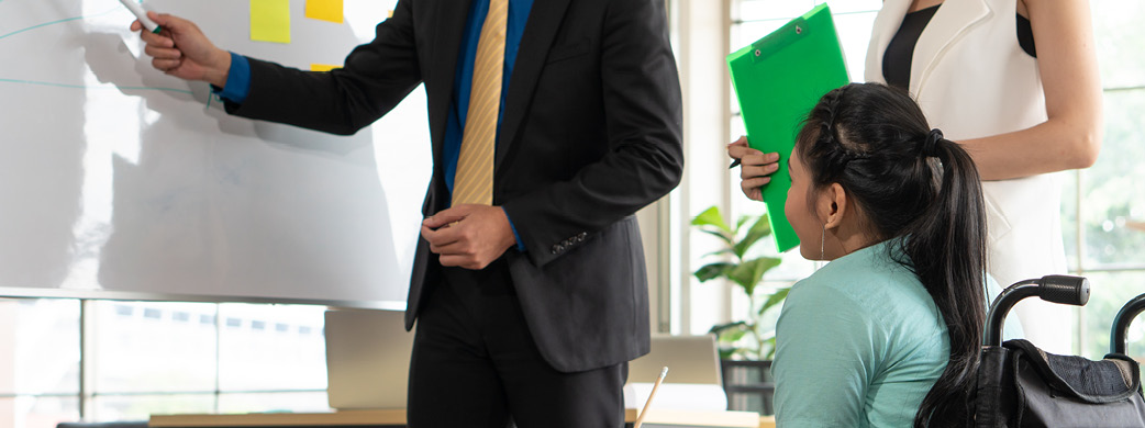 woman in wheelchair talking with colleagues
