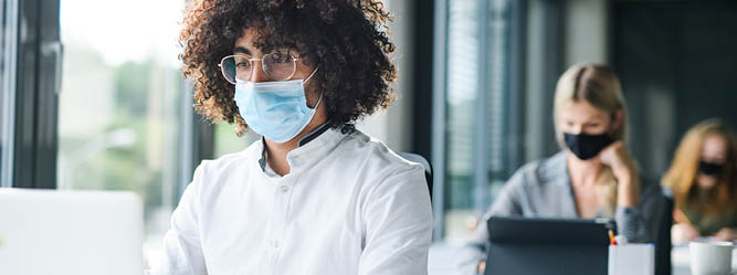 Man in mask working in office